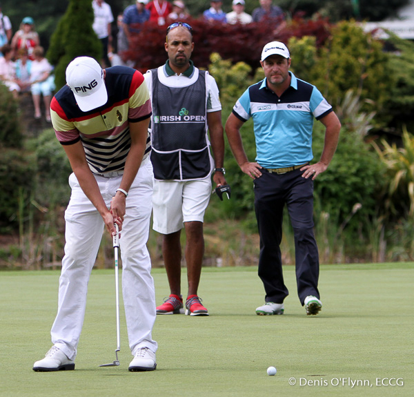 Marco Crespi and his caddy watch as Mathew Nixon holes out on the 18th