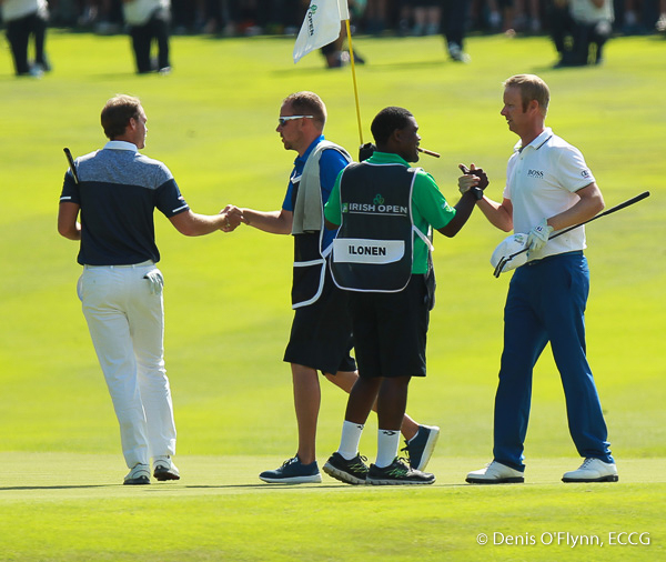 Mikko Ilonen right, is congratulated by his caddy on the 18th